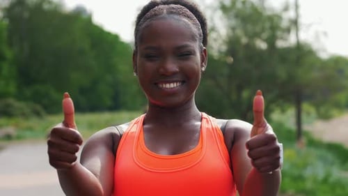 Smiling Woman Gives Thumbs Up in Green Park