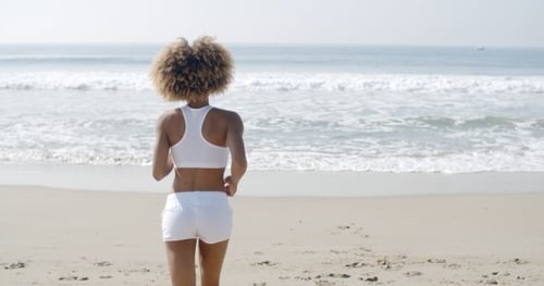 Woman Jogging On The Beach