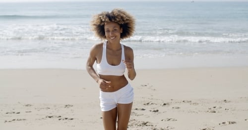 Woman Jogging On The Beach