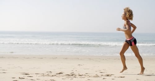 Woman Running On The Beach