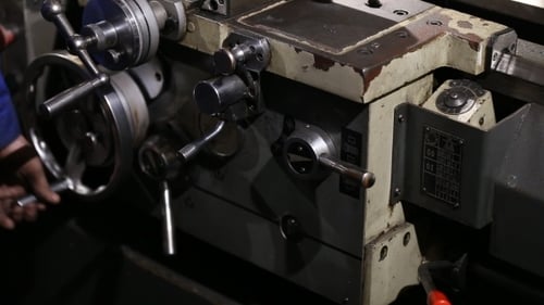 Hand operating lathe machine in industrial setting