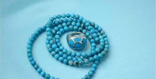 Turquoise Ring and Beaded Necklace on Blue Fabric