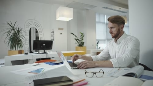 Man Working on Laptop in Modern Office