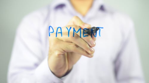 Hand Writes the Word Payment on Glass