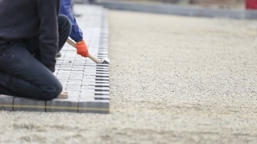 Construction Worker Laying Gray Pavers