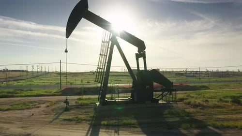 Oil Pump Jack Working at Oil Well Green Field at Summer Oil Production in USA