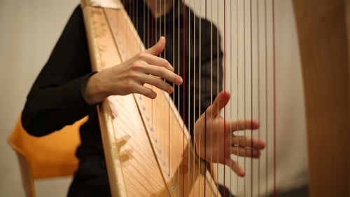 Hands Playing Strings of a Beautiful Harp