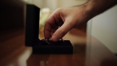 Close Up of Hand Grabbing Ring from Box