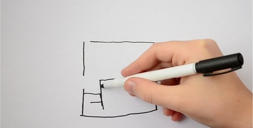 Hand Drawing a Maze on White Paper