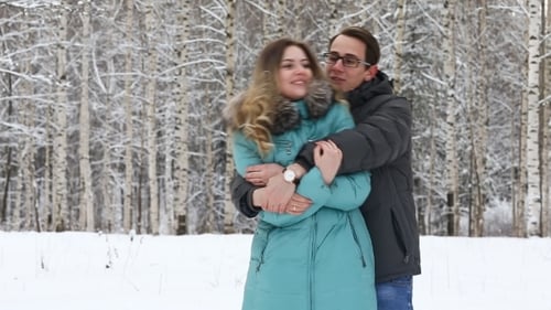 Glückliches junges Paar spaziert in einem Winterpark.