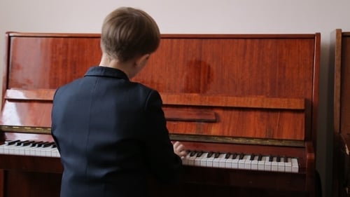 Person Plays Upright Piano Indoors