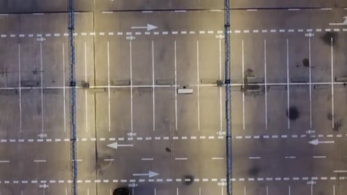 Almost empty top floor of multi story parking lot in downtown of Kaunas city. Directly above shot.