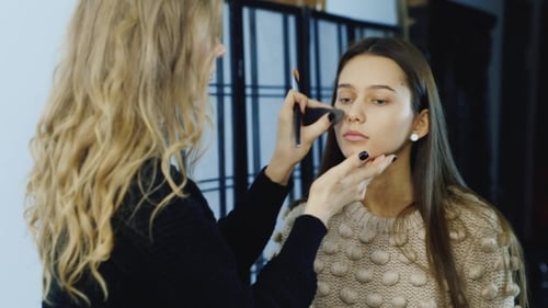 Makeup Artist Applying Foundation to Young Woman's Face