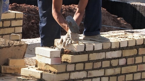 Bricklayer Carefully Building Brick Wall on Site