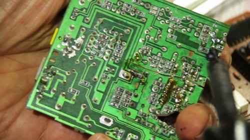 Close Up of Repairing a Green Circuit Board