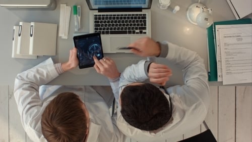 Doctors Analyze Brain Scan on Tablet in Office