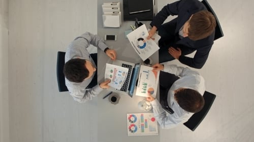 Kreatives Team, das Diagramme mit Laptop anzeigt und