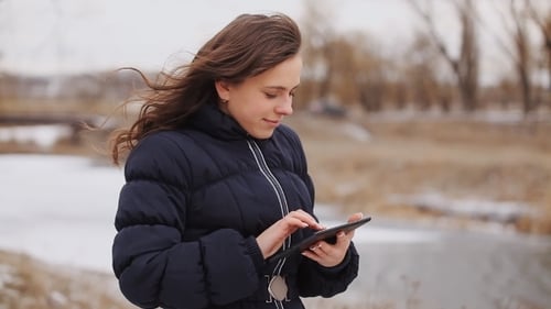 Beautiful Girl With a Tablet In The Winter Park