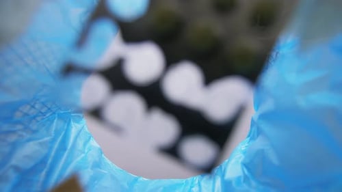 Hand Throwing Old Medicine Pills Into Trash Can