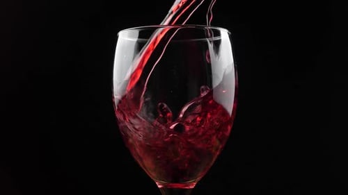 Pouring Red Wine into Glass on Black Background