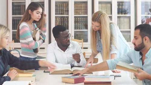 Diverse Multiracial Students Spending Leisure Time in Library with Big Old Book