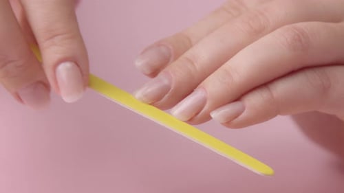 Woman Files Nails with Yellow File