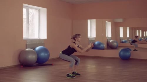 Woman Doing Squats in Fitness Studio