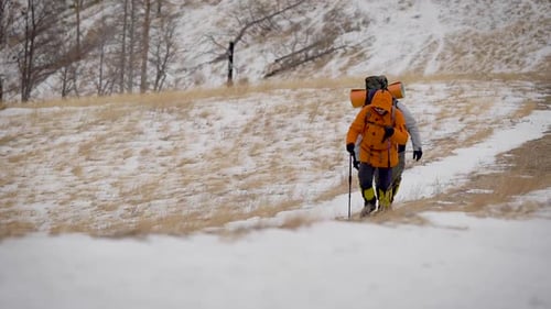 Hikers Trekking Through Snowy Mountain Landscape