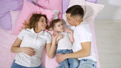 Happy Family Lying Together on Bed