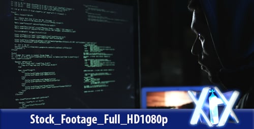 Hacker in Hoodie Working at Computer in Dark