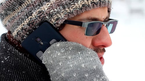 Homme parlant au téléphone à l'extérieur en hiver