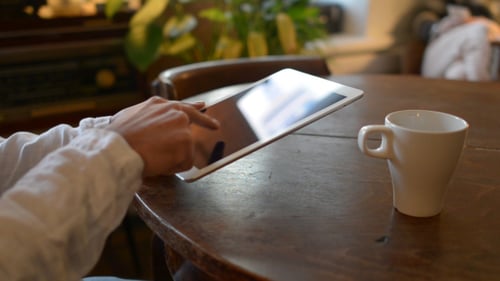 Tablet Use With Coffee on Wooden Table