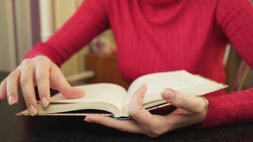 Woman's Hands Reading Book and Turning Pages