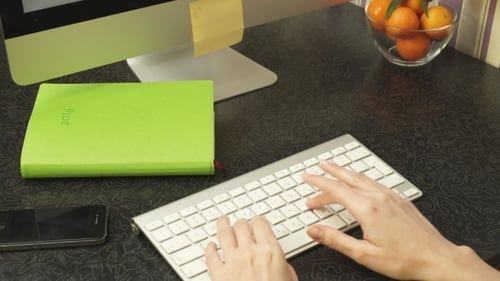 Hands Typing on Wireless Keyboard at Desk