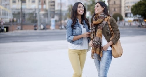 Two Stylish Women Chatting Outdoors In a Town