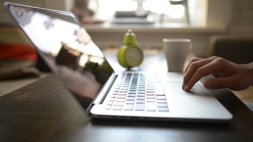 Typing on Silver Laptop Keyboard on Wooden Desk
