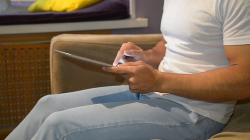 Young Adult Using Tablet Device While Relaxing