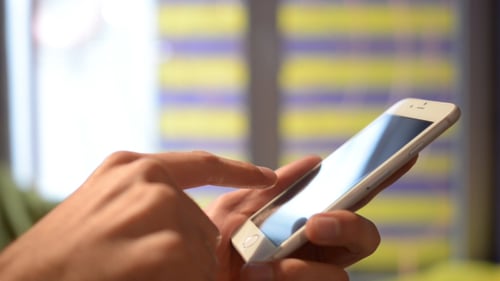 Hands Scrolling on White Smartphone Touchscreen