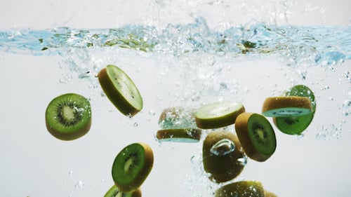 Kiwi Fruit Slices Falling Into Water