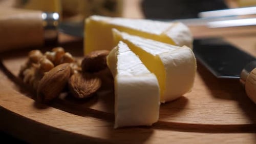 Cheese Selection with Nuts and Grapes on Board