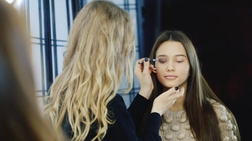 Makeup Artist Applying Eyeshadow to Woman
