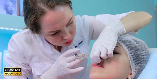El médico realiza un procedimiento para aumentar los labios