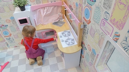 Girl Plays With Toy Kitchen Set Indoors