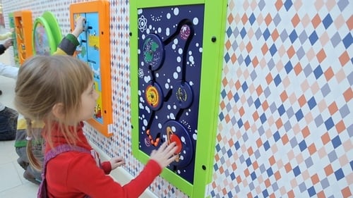 Children Engage with Colorful Interactive Wall Panel