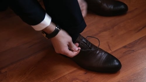 Man Leg And Hands Tying Shoe Laces