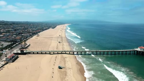 Stretch of Manhattan Beach With Pier On A Sunny Summer Day. - aerial pullback. Covid pandemic empty