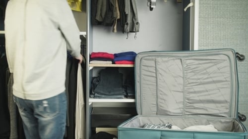 Person Packing Suitcase From Wardrobe for Trip