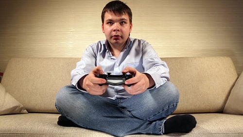Man Playing Video Game with Controller on Sofa