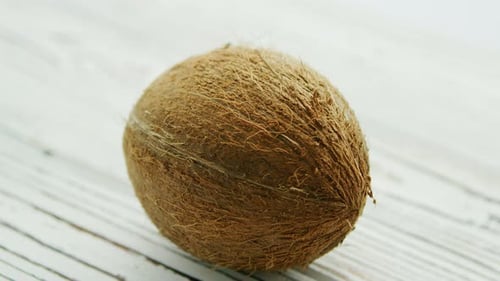 Ungeschälte braune Kokosnuss auf Tisch