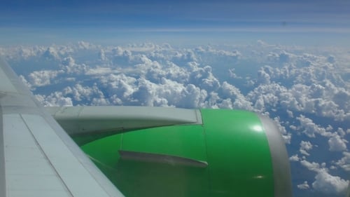 Airplane Flying Above White Clouds in Blue Sky